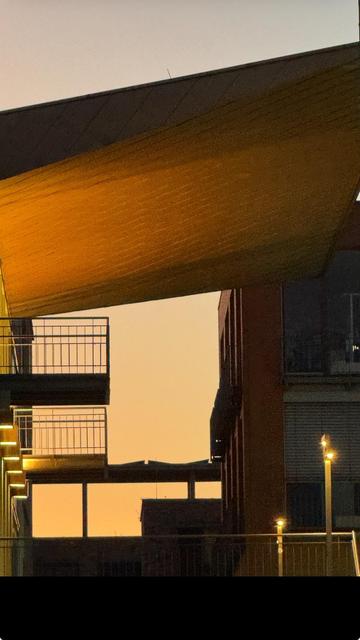 An architectural view featuring two buildings at sunset, highlighting a golden overhang and balcony railings, with soft lighting illuminating the structures against a gradient sky.

Eine architektonische Ansicht mit zwei Gebäuden bei Sonnenuntergang, die einen goldenen Überhang und Balkongeländer hervorheben, mit sanftem Licht, das die Strukturen gegen einen verläufenen Himmel beleuchtet.