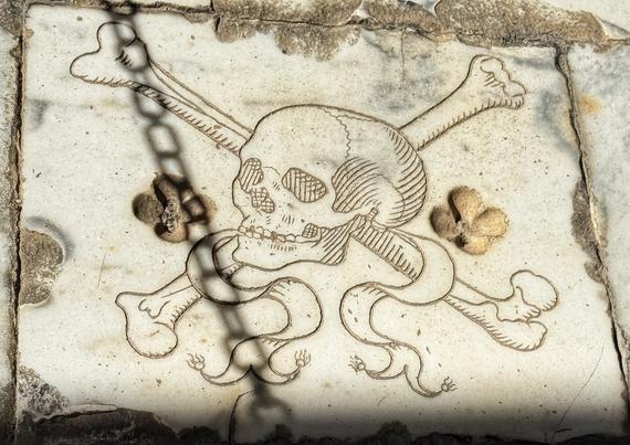 Photo: etching of skull and bones on a tombstone