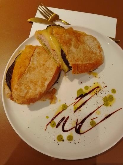Panino with porchetta, scamorza, eggplant and green sauce