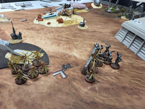 Star Wars Legion tabletop minis game with just-deployed Geonosians in the foreground and distant ewoks hiding behind a crashed X-wing.