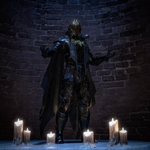 This image depicts a dramatic figure in ornate, dark armor standing in a commanding pose against a textured stone wall. The armored figure wears an elaborate helmet with a pointed crest and is clad in intricate medieval-style armor that appears metallic with blue-tinted highlights. A flowing cape or cloak drapes from the shoulders, and the armor features detailed decorative elements throughout, including ornate patterns on the chest plate and leg guards.
The figure stands with arms outstretched in a triumphant gesture. The scene is atmospherically lit by multiple melted candles arranged in two groups on the floor—three on the left side and three on the right side of the figure. The candles cast a warm, flickering glow that contrasts beautifully with the cool blue tones of the armor and the dark, shadowy stone wall backdrop. The overall composition creates a mystical, gothic atmosphere reminiscent of dark fantasy or medieval settings.
