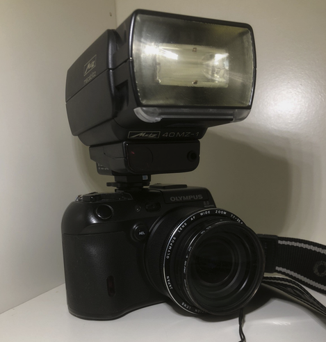 Eine Olympus CAMEDIA C-8080 Wide Zoom Kamera mit einem übergroßen Blitz von der Firma Metz.