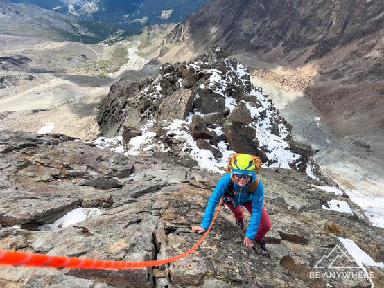 woman climbing on a rope on a steep mountain