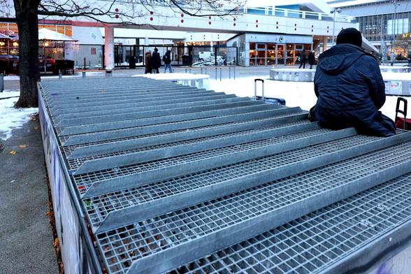 Ein Lüftungsschacht wo ein Gitter drauf liegt. Auf dem Gitter sind zusätzliche Stege angebracht um das liegen zu verhindern