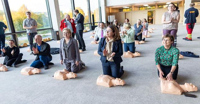 Abgeordnete kniend vor den Puppen für die Herzdruckmassage