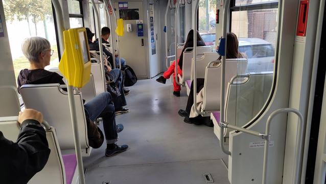 Straßenbahn innen mit Fahrgästen rechts und links