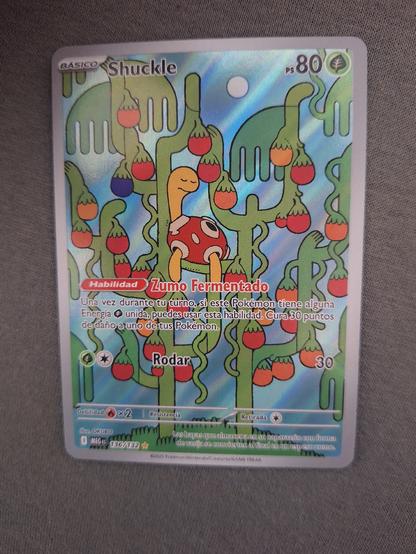 En la imagen la carta Shuckle del juego de cartas de pokémon con reflejos holográficos e ilustración especial alternativa del ilustrador OKUBO.