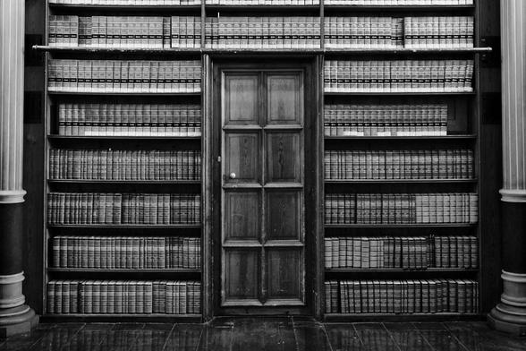 Schwarz-Weiß Foto von eine Bücherregal voll mit Bücher in einer alten Bibliothek; black and white photo of a shelf stuffed with bools in an old library