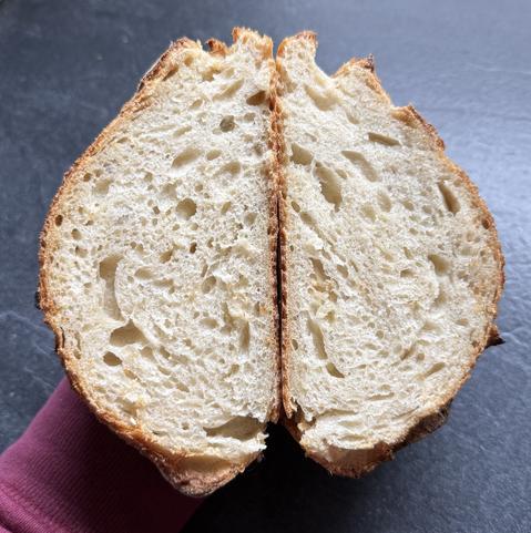 Aufgeschnittenes, frisch gebackenes Brot mit luftiger Krume und knuspriger Kruste.