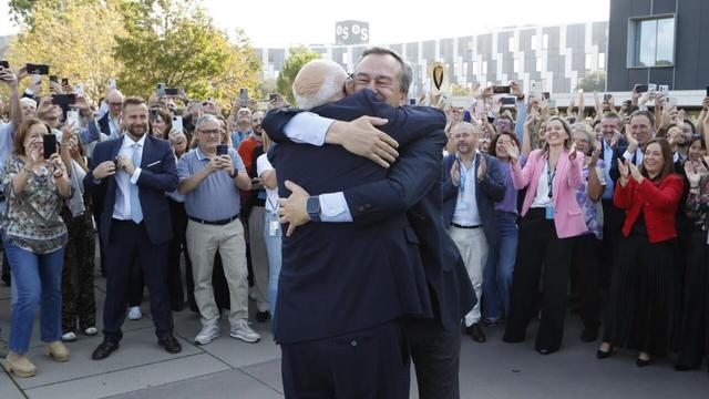 El presidente del banco Sabadell, Josep Oliu, y el consejero delegado, César González-Bueno, se abrazan delante de los empleados de la entidad a las puertas de su sede.