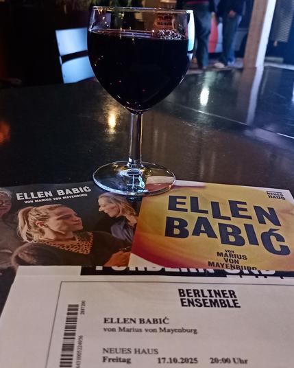 Das Ticket, das Programmheft und der Flyer mit einem Glas Rotwein