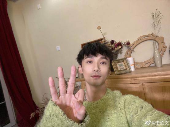 Li Bowen (Song Lan’s actor in The Untamed) holding up three fingers while wearing a fabulously cosy green sweater.
