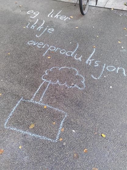 Kritt på asfalt. Teksten eg liker ikkje overproduksjon med bilete av ein fabrikk.