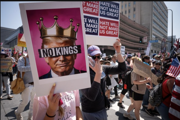Protesting crowd with no kings signs.