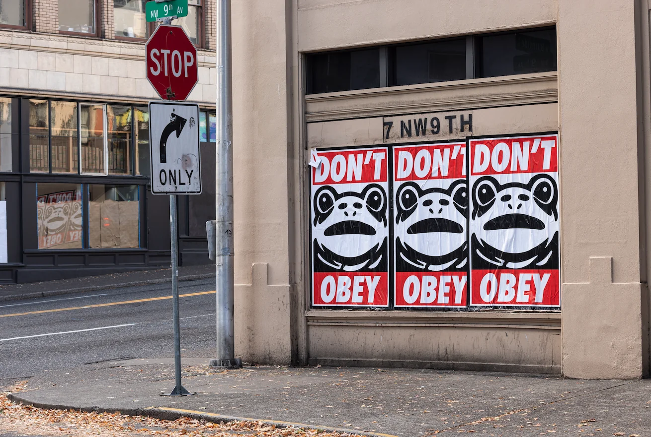 Three Frogs with text that reads Don't Obey as posters on a wall Found on Reddit  https://www.reddit.com/r/pics/comments/1o93rbh/oc_the_portland_frog_is_everywhere_in_portland/ https://i.redd.it/yv3oclgusovf1.png