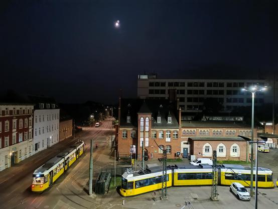 Betriebshof Köpenick, auf dem Hof steht eine Tram, eine andere fährt daran vorbei.