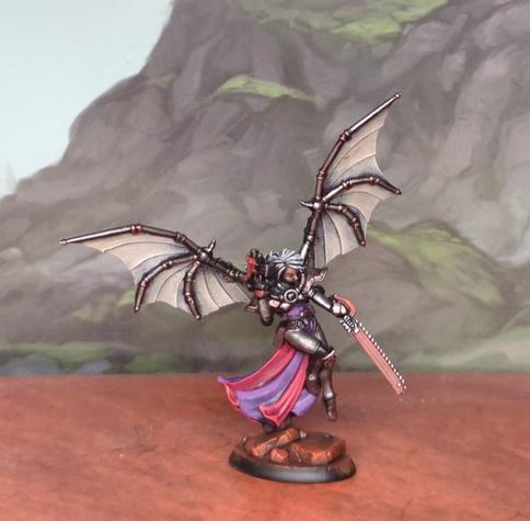 A painted miniature fur playing tabletop games. A Sister of Battle style miniature with pistol, chainsword, and mechanical wings.