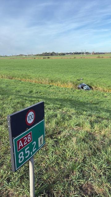 Langs de A28 bij knooppunt Hattemerbroek ligt een auto in de sloot