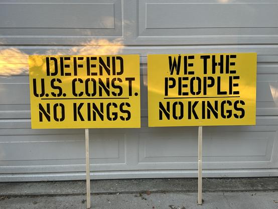 2 No Kings Day protest signs. “Defend U.S. Const. No Kings” and “We The People No Kings” getting ready for the No Kings protest in Santa Cruz CA.