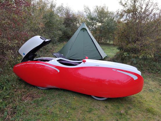 Tipitent op natuur camping met velomobiel er voor.