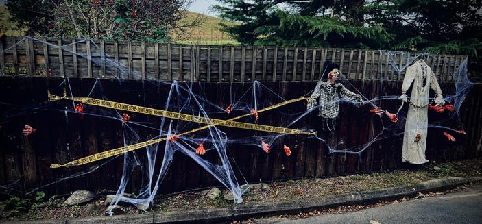 The fence, arms reach out under police tape with a headless ghost on the right