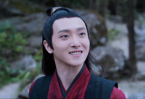 Good boy Wen Ning looks up at someone out of frame with a big smile on his face.