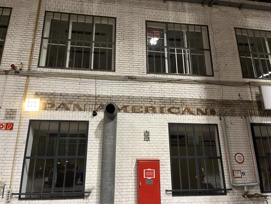 A photo of the wall inside hangar 7 at Berlin Tempelhof. Part of the brick wa has not been painted over and the logo PAN AMERICAN can still be seen.