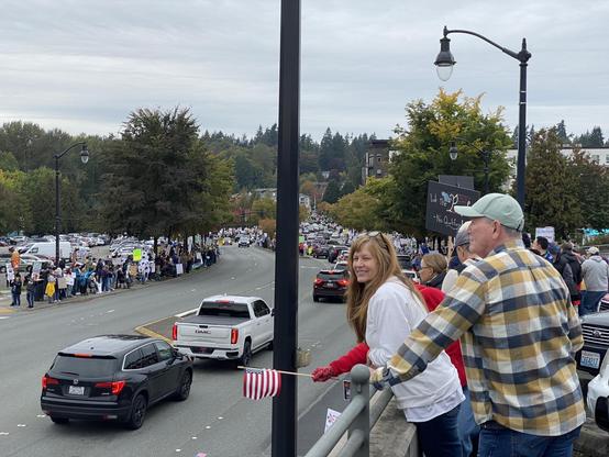 bothell woodinville road near bothell way, a big crowd on all sides with a middle-age white couple on the right closer up.