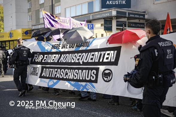 Auf diesem Bild führen die Demonstrant*innen ein langes Banner mit der Aufschrift "Für einen konsequenten Anfaschismus".