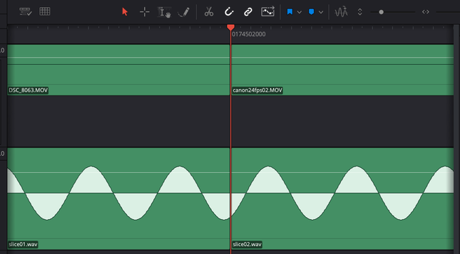 This is a creen capture of a video editor showing two tracks: one video and one audio. On each track there are two adjacent files that touch together and the junctions are right under the play head. The video track doesn't show any image but the clips are identified by their filename. The two audio wav files are named slice01.wav and slice02.wav. The audio track shows a continuous sine wave that is perfectly smooth, that was hoped for!