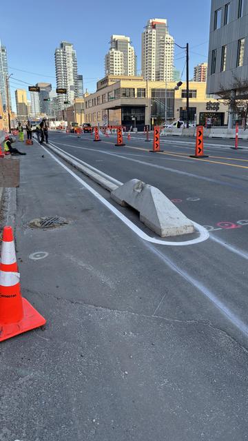 Road work being done including curbs for a protected bike lane