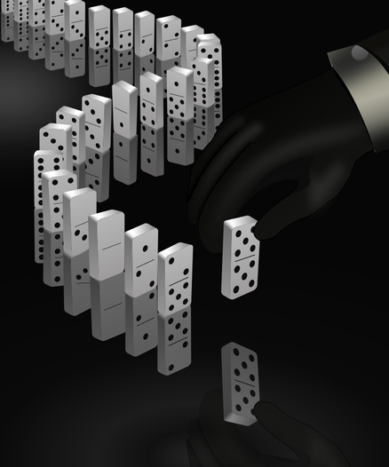 Devant une chaîne dominos disposés en serpentin, une main gantée tient un ultime domino s’aprétant à le poser en bout de chaîne.