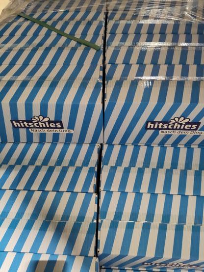 Karton gestapelt auf einer Palette, von vorne gesehen. Die Kartons sind hell- und blau gestreift. Ein verwirrendes Muster entsteht.