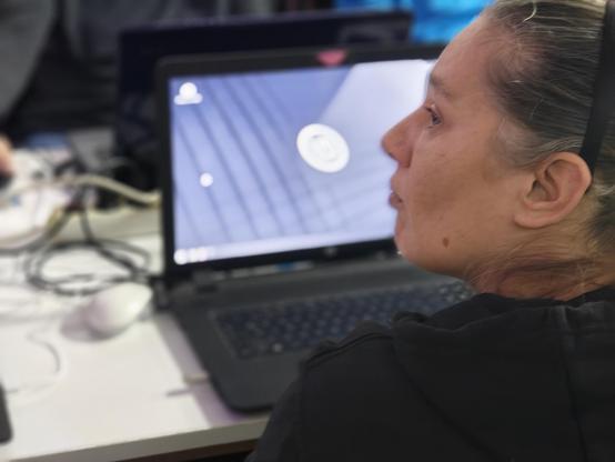 Eine Person sitzt vor einem Notebook.