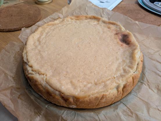 Auf den Fotos ist ein veganer Käsekuchen zu sehen, der aus Seidentofu zubereitet wurde. Trotz der pflanzlichen Zutaten wirkt er auf den ersten Blick kaum von einem klassischen Quarkkuchen zu unterscheiden:

Die Füllung ist hell, glatt und cremig, mit einer zarten Bräunung auf der Oberfläche. Seidentofu sorgt hier für die typische feine, fast schmelzende Textur.

Der Kuchen ist gleichmäßig gebacken und hat eine kompakte, schnittfeste Konsistenz, ohne brüchig zu wirken.

Der Mürbeteigboden ist dick genug, um Stabilität zu geben, aber dünn genug, um die Füllung nicht zu überdecken.

Die Oberfläche ist schlicht gehalten – ohne Toppings oder Verzierungen, was die natürliche Optik betont.

Serviert wird der Kuchen stilecht auf einem weißen Teller, oft mit einem Becher Tee – perfekt für eine ruhige Kaffeepause.


Trotz (oder gerade wegen) seiner veganen Basis wirkt der Kuchen authentisch, hausgemacht und puristisch – ein schönes Beispiel dafür, wie man klassische Rezepte modern und tierfrei umsetzen kann.