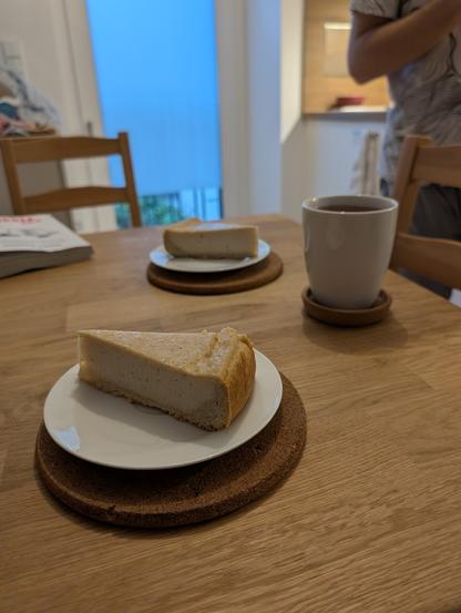 Auf den Fotos ist ein veganer Käsekuchen zu sehen, der aus Seidentofu zubereitet wurde. Trotz der pflanzlichen Zutaten wirkt er auf den ersten Blick kaum von einem klassischen Quarkkuchen zu unterscheiden:

Die Füllung ist hell, glatt und cremig, mit einer zarten Bräunung auf der Oberfläche. Seidentofu sorgt hier für die typische feine, fast schmelzende Textur.

Der Kuchen ist gleichmäßig gebacken und hat eine kompakte, schnittfeste Konsistenz, ohne brüchig zu wirken.

Der Mürbeteigboden ist dick genug, um Stabilität zu geben, aber dünn genug, um die Füllung nicht zu überdecken.

Die Oberfläche ist schlicht gehalten – ohne Toppings oder Verzierungen, was die natürliche Optik betont.

Serviert wird der Kuchen stilecht auf einem weißen Teller, oft mit einem Becher Tee – perfekt für eine ruhige Kaffeepause.


Trotz (oder gerade wegen) seiner veganen Basis wirkt der Kuchen authentisch, hausgemacht und puristisch – ein schönes Beispiel dafür, wie man klassische Rezepte modern und tierfrei umsetzen kann.