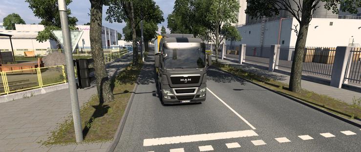 Bildschirmfoto aus dem Spiel Euro Truck Simulator 2. Es ist ein vor einer Haltelinie an einer Ampel stehender LKW von vorne zu sehen. Rechts neben dem LKW sind ca. 1m Platz.