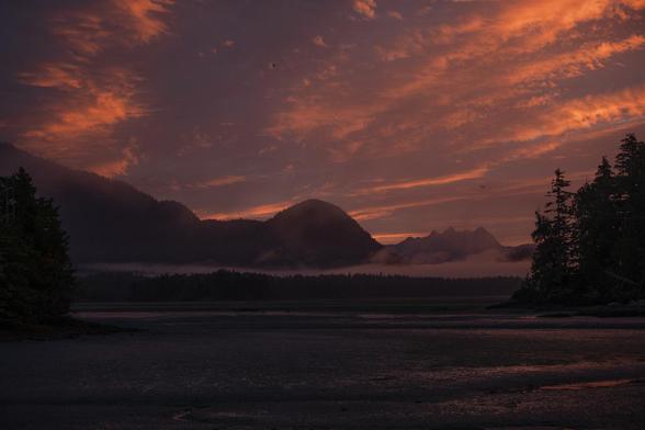 Sunrise in progress. The sky is peachy-pink, the land lit by the same colours.