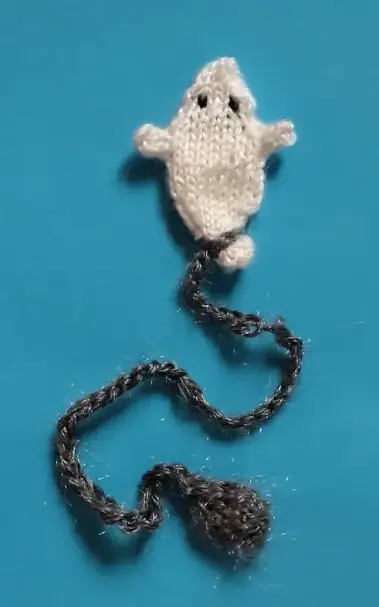 Petit fantôme blanc relié à son boulet gris par une chainette. Le tout sur fond bleu.