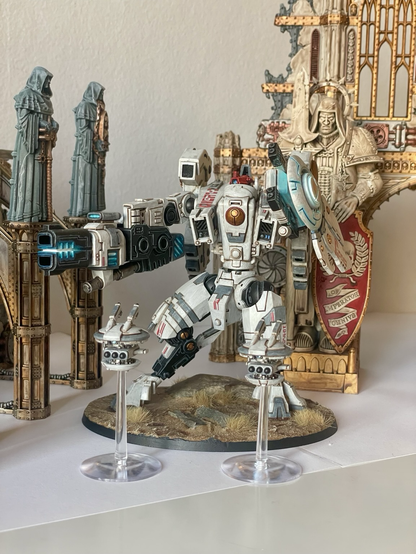 A finished riptide battlesuit with missile drones in front of sector imperialis ruins. Front view.