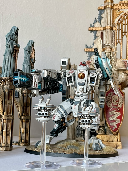 A finished riptide battlesuit with missile drones in front of sector imperialis ruins. Front view from below.