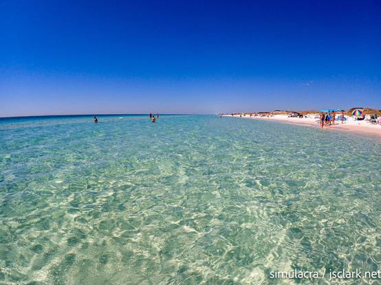Crystal clear saltwater over white sandy bottom; beach visible on the right.