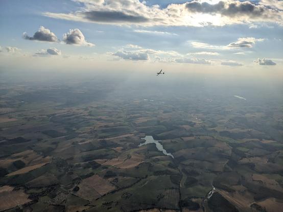 Picture of a glider I took from another glider at 1000m high above the lauragais in france. The sun is highlighting the clouds juste above the glider.