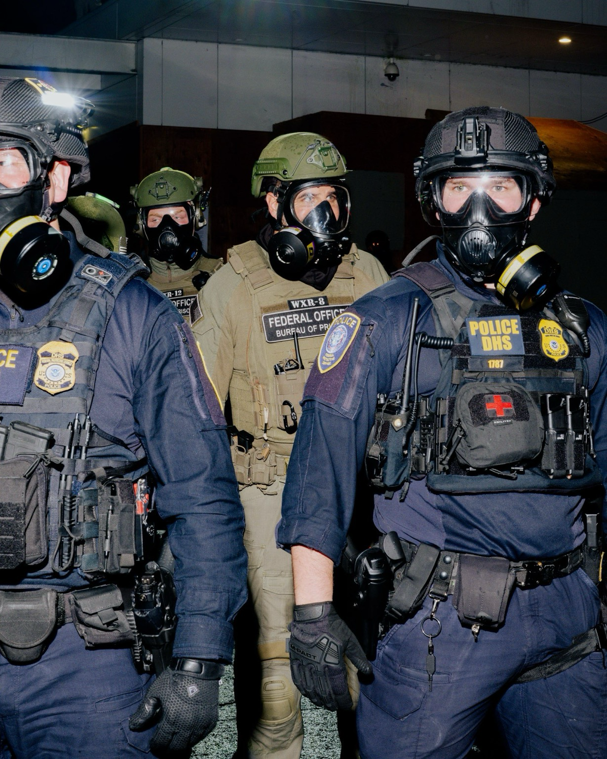 Federal agent in fatigues with a patch that says “WXR-19 federal bureau of prisons”