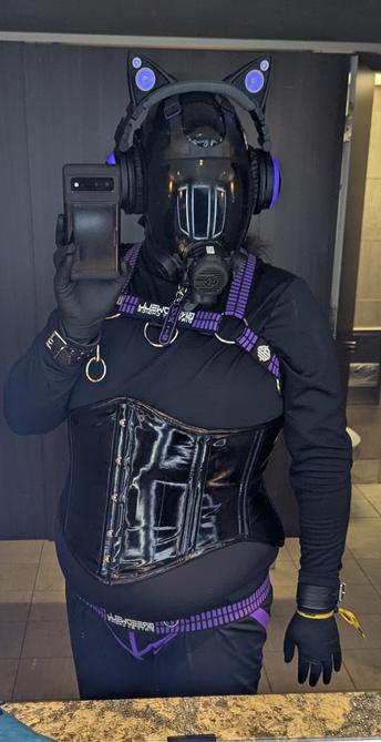 Nyxie in a cloth drone outfit with closet and purple jock and bulldog harness