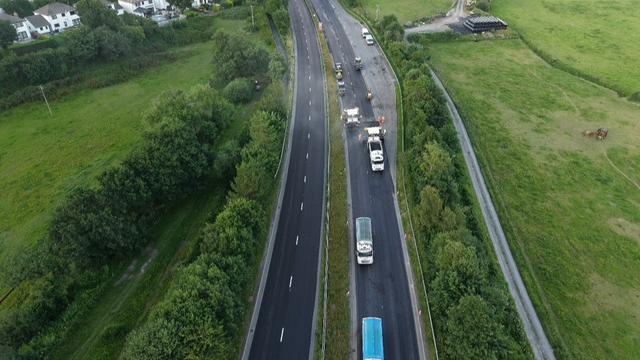 Aerial view of heavy machinery resurfacing the A40 dual carriageway near Carmarthen, part of a Welsh Government highways improvement scheme.