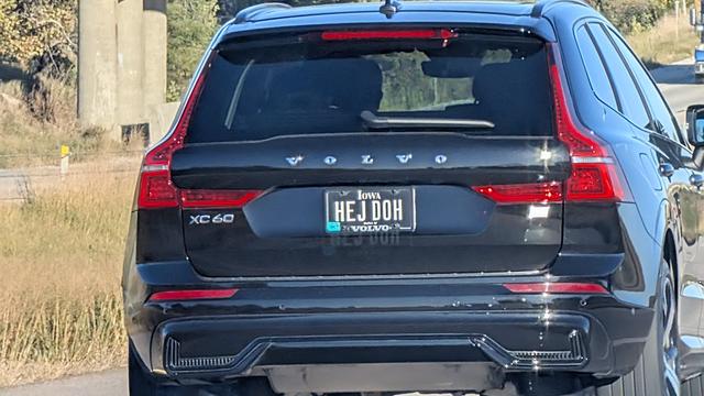 A zoomed in photo of the back of a Volvo with a license plate that reads "HEJ DOH".