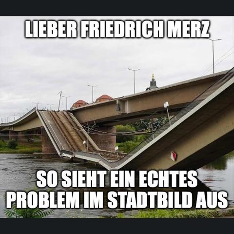 Ein Bild zeigt eine Brücke über einem Fluss. Die Brücke ist nicht gerade, sondern deutlich durchgebrochen und abgesenkt. Ein Teil der Brücke ragt schräg nach unten in das Wasser. Im Hintergrund sind Gebäude mit roten Dächern und Bäume zu sehen. Oben im Bild steht in weißen Buchstaben auf schwarzem Grund „LIEBER“. Darunter, auf der gleichen Weise formatiert, steht „SO SIEHT EIN ECHTES PROBLEM IM STADT BILD AUS“.