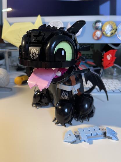 The completed Lego model on my desk. His forked tongue is hanging out and a fish is on the ground next to him.