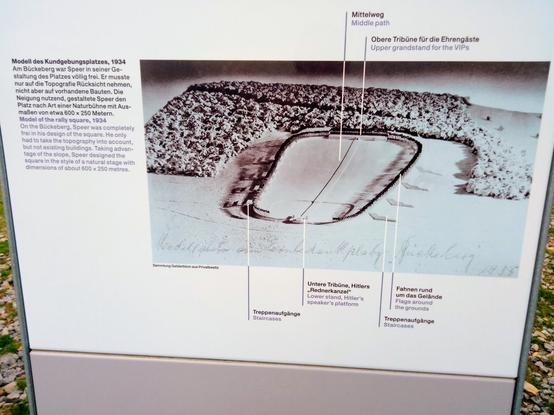 Detail einer Ausstellungstafel mit einem S/W-Foto eines Modells des Kundgebungsplatzes am Hang des Bückebergs von 1934 mit Erläuterungen.